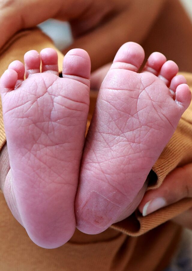 Recto de la carte : les deux petits pieds d'un nouveau-né, tenus dans les mains de sa mère
